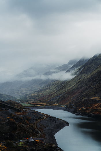 A serene aerial view of a foggy valley with a winding river in Wales, UK. HD phone wallpaper