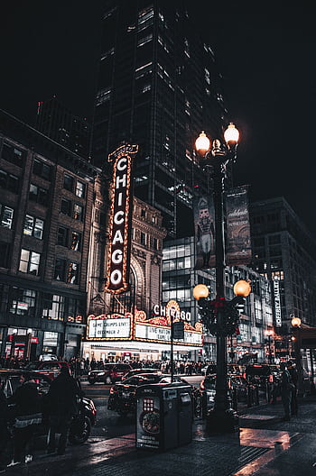 Captivating nighttime view of Chicago Theatre illuminated with city lights and bustling traffic. HD phone wallpaper