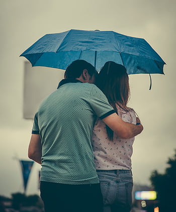 A couple embraces under a blue umbrella in a rainy street scene, evoking love and warmth. HD phone wallpaper