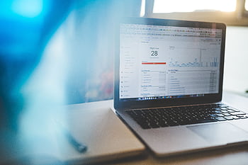 Laptop displaying Google Analytics in a modern workspace, highlighting digital analytics and technology. HD wallpaper