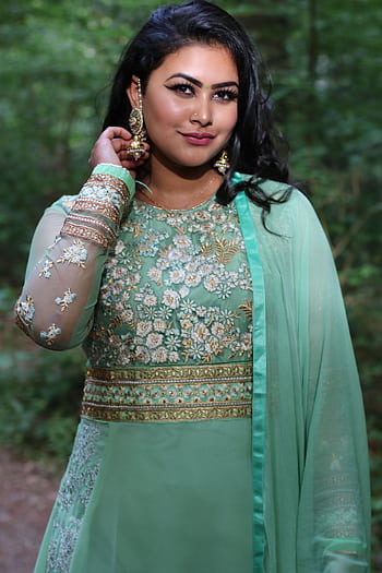 Beautiful woman in traditional attire posing elegantly in a lush forest setting. HD phone wallpaper