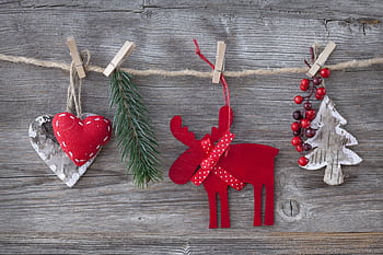 Heartfelt rustic Christmas decorations on wood, featuring a red moose, heart, and tree. HD wallpaper