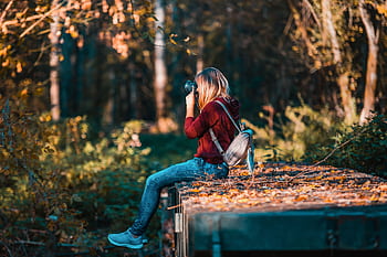 Young woman takes in a vibrant forest setting, embracing nature. HD wallpaper