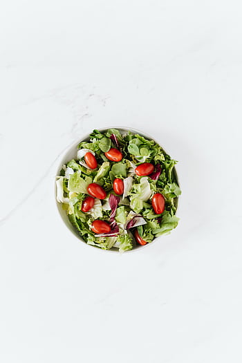 Top view of a fresh and healthy green salad with ripe grape tomatoes in a bowl. HD phone wallpaper