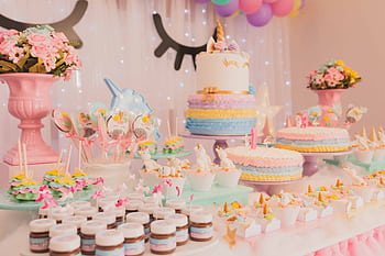 A vibrant unicorn-themed birtay party setup with cakes, cupcakes, and decorations. HD wallpaper