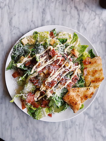 Tasty Caesar salad topped with bacon, cheese, and drizzled sauce, served with crispy bread. HD phone wallpaper