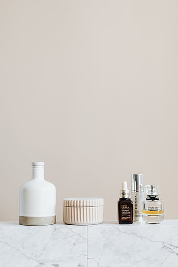 Aesthetic display of skincare products on a marble surface with beige background. HD phone wallpaper