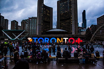 Vibrant evening at Toronto City Hall with festive crowd enjoying the cityscape. HD wallpaper
