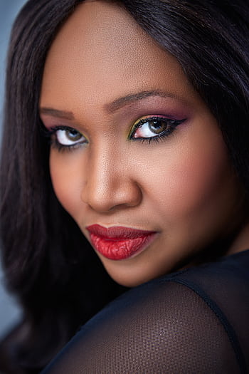 Stunning close-up portrait of a woman with vibrant makeup and confident expression. HD phone wallpaper