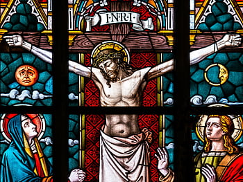 Detailed stained glass depiction of the crucifixion featuring Christ and religious icons. HD wallpaper