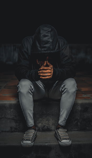 A man in a hoodie sits alone on steps, deep in thought at night. HD phone wallpaper