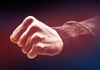 A powerful close-up of a clenched fist, conveying strength and determination. HD wallpaper