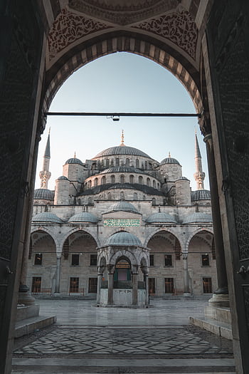 The stunning Blue Mosque in Istanbul, captured through an ornate archway, showcasing its architectural beauty. HD phone wallpaper