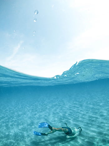 A snorkeler enjoys the crystal-clear waters of Sardinia, Italy, showcasing underwater serenity. HD phone wallpaper