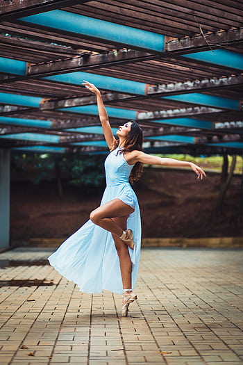 Graceful ballerina dances outdoors in a flowing blue dress. HD phone wallpaper