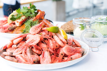 Plate of shrimp and seafood garnished with lemon and herbs, perfect for a gourmet meal. HD wallpaper