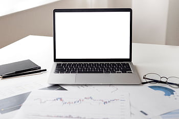 Open laptop with financial documents on a desk, ideal for business and technology themes. HD wallpaper