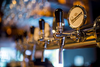Focused of a shiny beer tap in a stylish bar with a blurred background. HD wallpaper