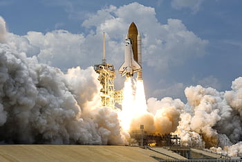 Witness the powerful launch of a space shuttle amidst massive clouds of smoke against a bright sky. HD wallpaper