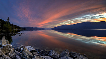 Okanagan Lake at Sunset, rocks, lake, twilight, shore, reflection, clouds, nature, mountains, forest, sunset HD wallpaper