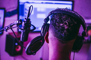 Back view of a music producer working in a vibrant recording studio setting. HD wallpaper