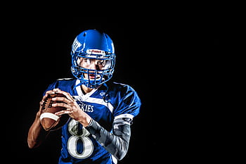 A focused American football quarterback poised to throw during a game. HD wallpaper