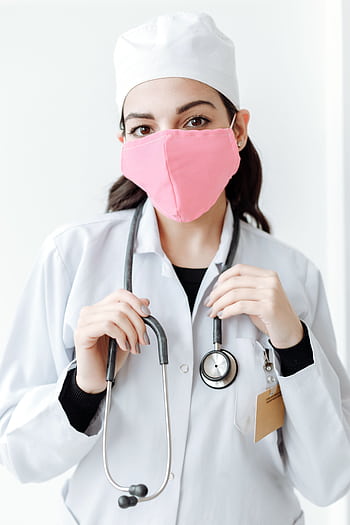 A doctor wearing a pink face mask and a stethoscope, symbolizing health and protection. HD phone wallpaper