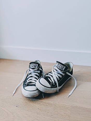 Two classic black sneakers with white shoelaces, perfect for casual style. HD phone wallpaper