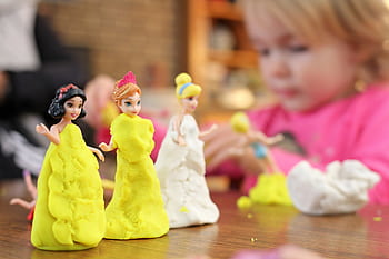 A child enjoying creative play with colorful clay figurines indoors. HD wallpaper