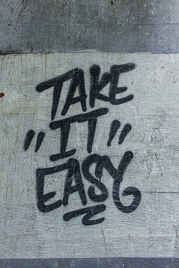 Black graffiti text 'Take it Easy' on a textured concrete wall. HD phone wallpaper