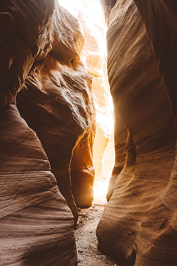 Idyllic scene of sunlight streaming through a slot canyon with smooth rock formations. HD phone wallpaper