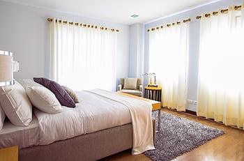 Bright modern bedroom with sunlight, cozy decor, and soft furnishings. HD wallpaper
