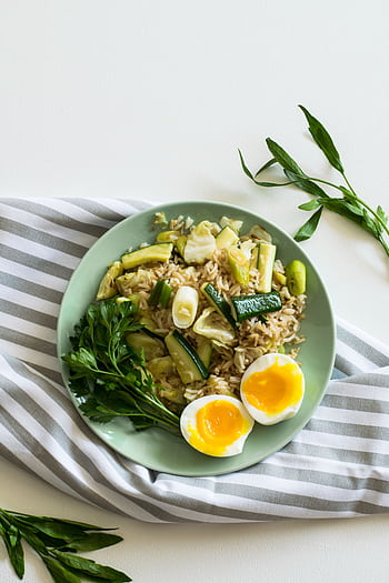 A top view of a healthy vegetable rice dish with soft-boiled eggs on a light green plate. HD phone wallpaper