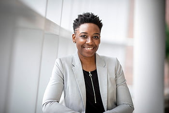 Confident African American businesswoman smiling inside a modern office space. HD wallpaper