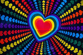 Colorful heart design with rainbow gradients and radiant pattern of small hearts on black background. HD wallpaper