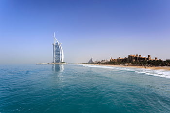 Iconic Burj Al Arab overlooking the pristine Dubai beach, perfect for travel and leisure. HD wallpaper