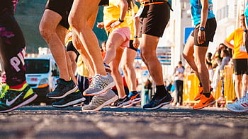 Group of runners participating in a city marathon during daylight. HD wallpaper