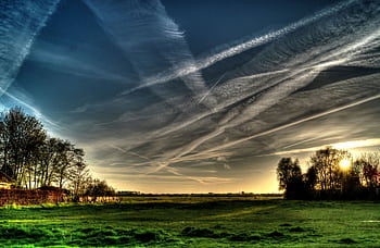 Beautiful countryside landscape with dramatic clouds at sunset, showcasing vibrant colors and natural beauty. HD wallpaper