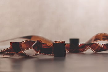 A retro filmstrip softly focused against a blurred background, evoking nostalgia. HD wallpaper