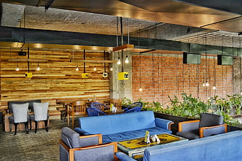 A contemporary café in Ahmedabad showcasing modern furniture and industrial elements. HD wallpaper