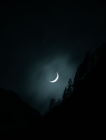 Crescent moon glowing in a mysterious night sky over the forested landscape of Slovenia. HD phone wallpaper