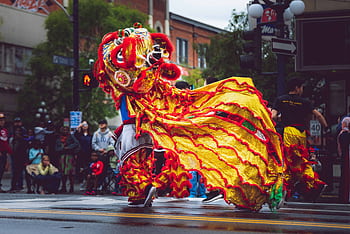 Vibrant dragon dance performance during a street parade in Victoria, BC, Canada, celebrating cultural heritage. HD wallpaper