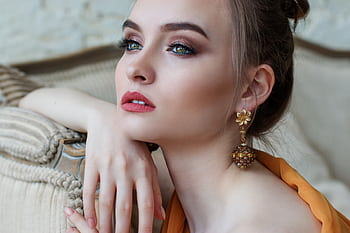 Stunning close-up portrait of a woman with elegant makeup and jewelry, epitomizing modern fashion and beauty. HD wallpaper