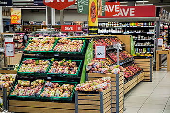 Colorful produce aisle in a supermarket showcasing fresh apples with discount signage. HD wallpaper