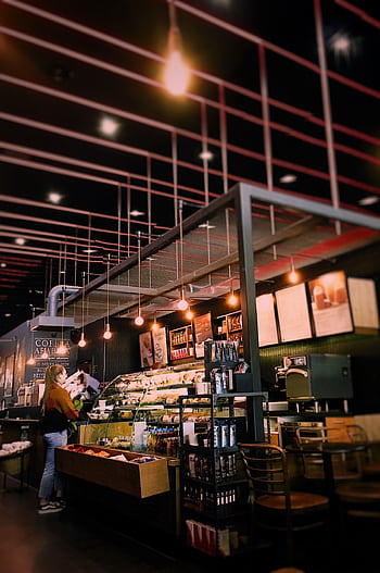 Warm and inviting café interior with modern lighting and seating. Perfect for a relaxing coffee break. HD phone wallpaper
