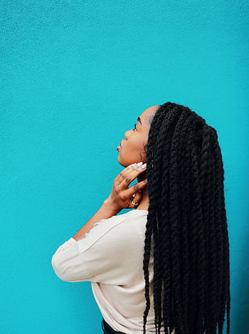 A stylish portrait of an adult woman with braided hair against a vibrant cyan background. HD phone wallpaper