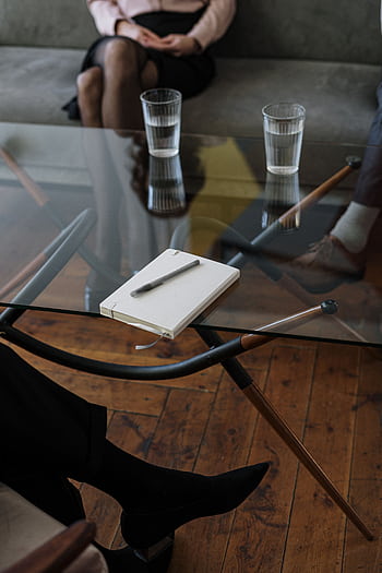 Close-up of a counseling session with two glasses of water and a notepad on a glass table. HD phone wallpaper