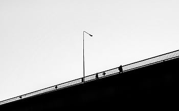Black and white of people silhouetted on a bridge in Vilnius. HD wallpaper