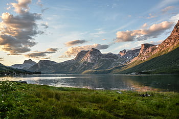 Beautiful view of a tranquil Norwegian fjord surrounded by mountains and reflecting sky at sunset. HD wallpaper