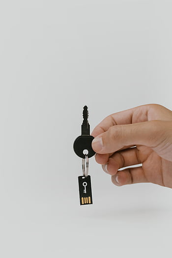 Close-up of a hand holding a key and USB with copyspace. HD phone wallpaper